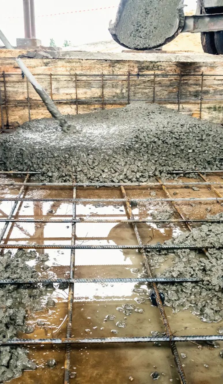 Concrete being poured into a rebar-reinforced foundation form