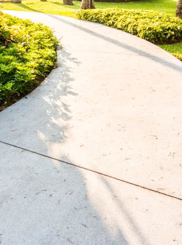 Finished concrete walkway curving through a landscaped garden