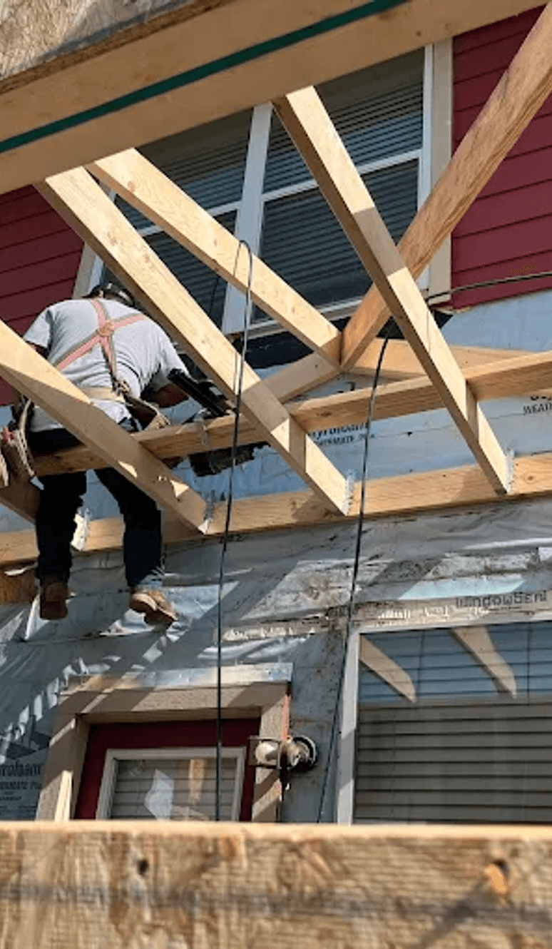 Crew framing a home addition with new wood rafters