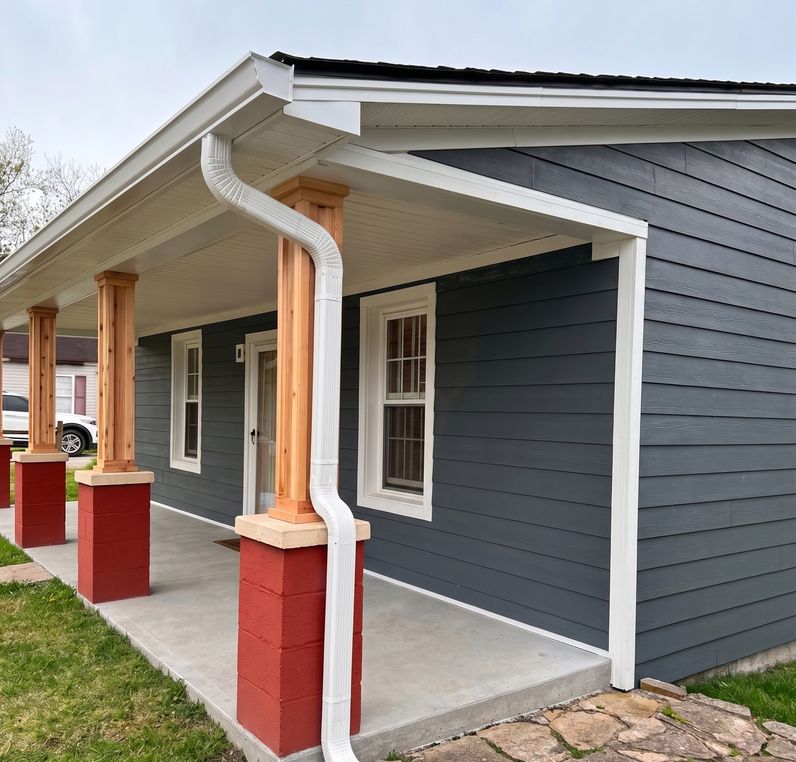 Front porch addition with dark gray siding, white trim, and stained wood columns on brick foundation